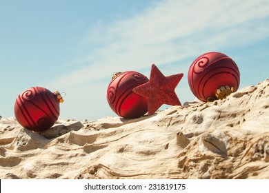 red Christmas decorations with sand and driftwood at a New Zealand beach  - Powered by Shutterstock