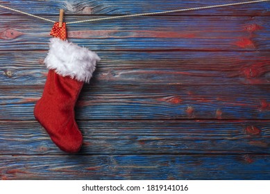 Red Christmas Stocking Hanging Over Blue Rustic Wooden Background