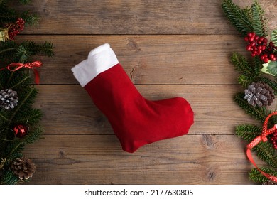 Red Christmas stockings on a rustic wooden wall background with Christmas decoration, fir tree and cone, red ribbon. Epiphany Befana's stockings or Santa Claus stocking for sweet - Powered by Shutterstock