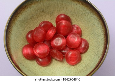 Red Cinnamon Hard Candy In Brown Bowl On Pink Background
