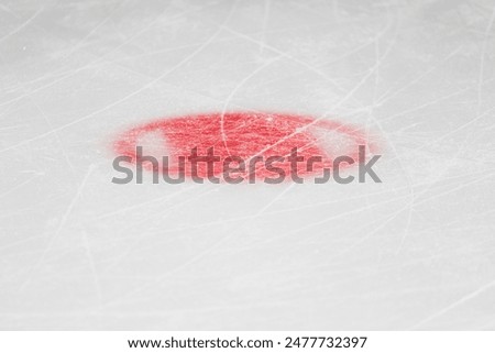 Red circle on ice marking close up - face off spot on hockey rink
