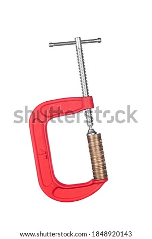 A red clamp squeezing a stack of coins.  For use and a financial inference such as savings, wealth, retirement, debt.