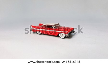 Red classic toy car with whitewall tire and white stripe
