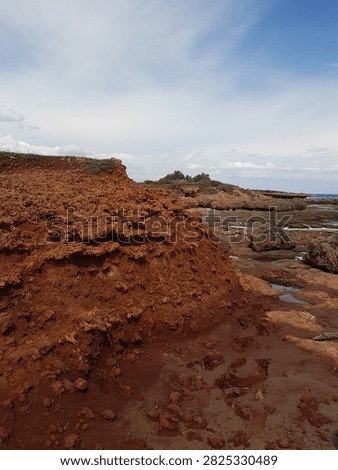 Red Clay Cliff Eroding Along Rocky Coastline, Puglia, Italy