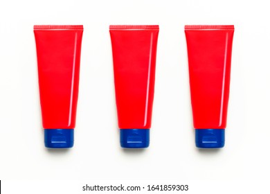 Red Clean Empty Tube Of Cream Or Gel For Hands, Face, Body On White Background. Flat Lay Top View Copy Space. Mock-up Of Cosmetics Spa Cream Bottles Container. Template For Design And Logo Application