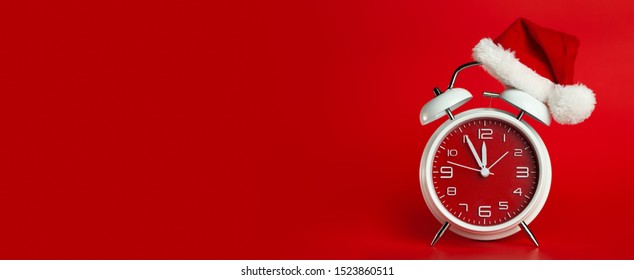 Red clock with Christmas Santa hat. Time for Christmas shopping concept. Blank red space for text. - Shutterstock ID 1523860511