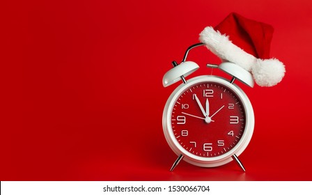 Red clock with Christmas Santa hat. Time for Christmas shopping concept. Blank red space for text. - Shutterstock ID 1530066704