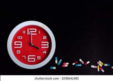 red clock with pills in both tablets and capsules layout as text 
