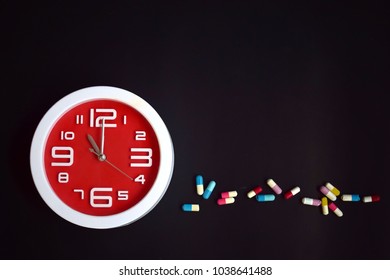 red clock with pills in both tablets and capsules layout as text 