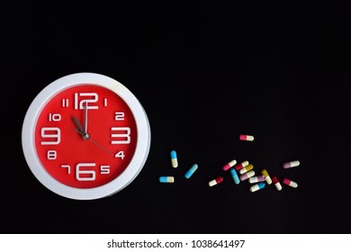 red clock with pills in both tablets and capsules layout as text 
