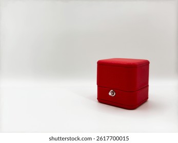 Red closed rectangular leather wedding ring box on white background right side of image front view macro. High quality photo