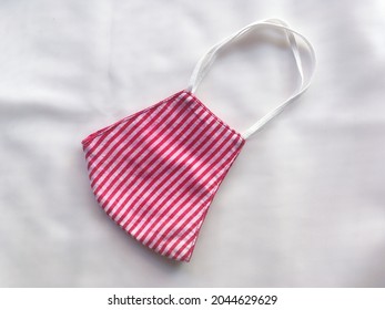 Red Cloth Mask With White Stripes On A White Background