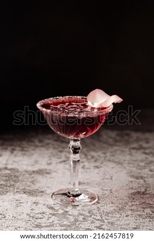 Red cocktail in glass on black background