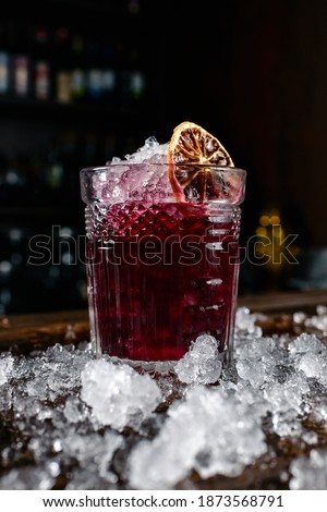 Red cocktail with raspberries and orange, Red cocktail with ice at the bar