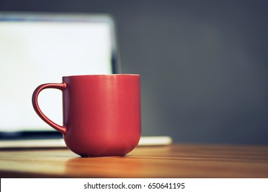 red coffee cup and laptop in office table. business concept - Powered by Shutterstock