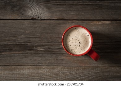 Red Coffee Cup On Wooden Table. View From Top 