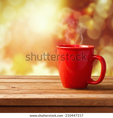 Red coffee cup over autumn background