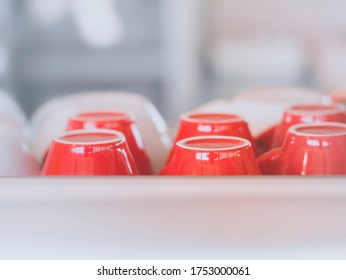 Red Coffee Cup Upside Down Arranged Together On Glass Shelves.