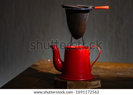 red coffee maker and cloth filter, with dark background. red teapot. coffee. rustic coffee
