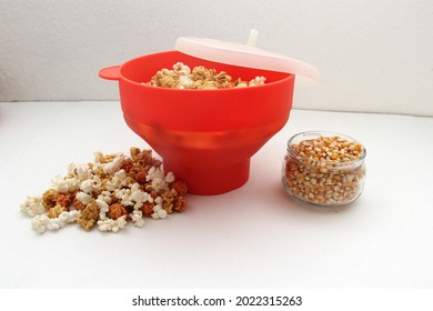 Red Collapsible Microwave Silicone Popcorn Bowl With Fresh Popcorn And Corn All Ready For Movie Watching
