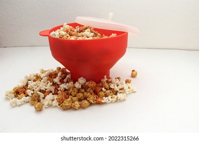 Red Collapsible Microwave Silicone Popcorn Bowl With Fresh Popcorn And Corn All Ready For Movie Watching
