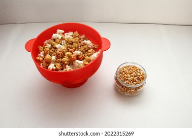 Red Collapsible Microwave Silicone Popcorn Bowl With Fresh Popcorn And Corn All Ready For Movie Watching
