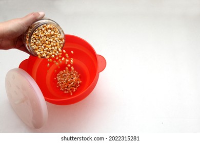 Red Collapsible Microwave Silicone Popcorn Bowl With Fresh Popcorn And Corn All Ready For Movie Watching
