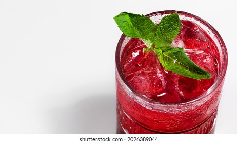 Red color berry lemonade or iced tea with mint close-up. Summer refreshing soft drink