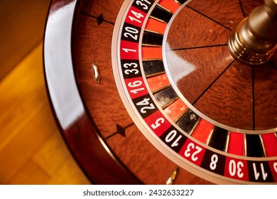 Red color casino roulette, poker game. roulette wheel. Casino theme, betting, online casino, bets, winnings. wooden casino roulette wheel with ball. Luxury roulette. close-up image - Powered by Shutterstock