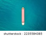 Red color container ship at sea shot from above. Scenic waterscape and lonely boat engaged in export and import business and logistics. Shipping cargo. Water transport. Aerial view of the sea and boat