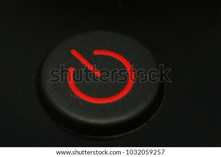 Red color power button macro closeup on black background