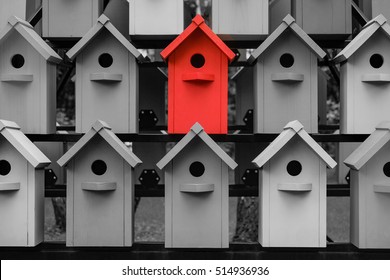 Red Color Wooden Birdhouse Stand Out From The Crowd. Metaphor To Business Concept. Stands Out Among The Gray Of Similar Objects. Notable Among The Competitors.