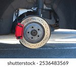 Red Colored Brake Caliper Cover And A Perforated Brake Disc Of A Sports Car. High Performance Car Brake System Condition Checking