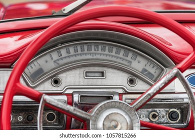 Red colored old american car details, wheel and speedometer.