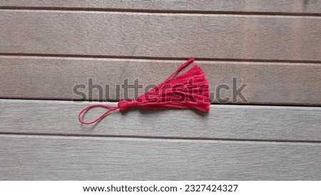 red colored tassels on a wooden background. copy space