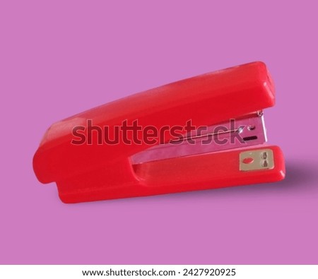 Red colour stapler with beautiful pink background. 