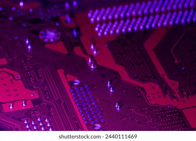 red computer electronic circuit board with blue illumination. closeup. selective focus.