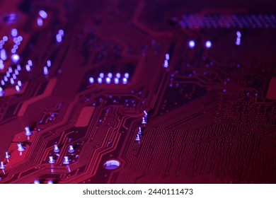 red computer electronic circuit board with blue illumination. closeup. selective focus.