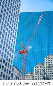 Red Constructiion Crane Outside Modern Buildings In Downtown Austin Texas. Urban City Landscape With Views Of Tall Apartments, Office Units And Construction Machine.