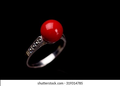 Red coral silver ring against black background