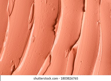 Red cosmetic clay (alginate facial mask, face cream, body wrap) texture close up, selective focus. Abstract background with brush strokes. 