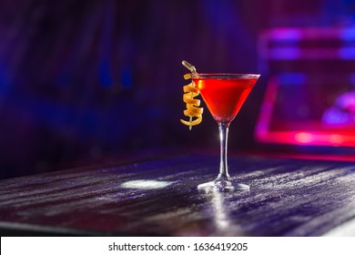 Red Cosmopolitan Cocktail With Orange Peel On The Table On Nightclub Background Side View