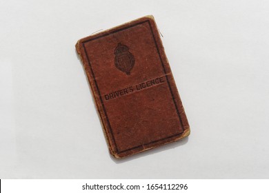 The red cover of an old British driving licence book isolated on a white background circa 1930, The annual fee for the licence was 5 shillings in the old British Currency.