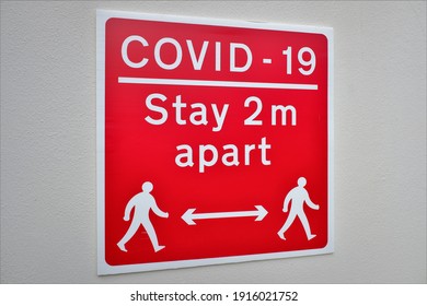 Red Covid-19 Stay 2 Metres Apart Sign On White Wall