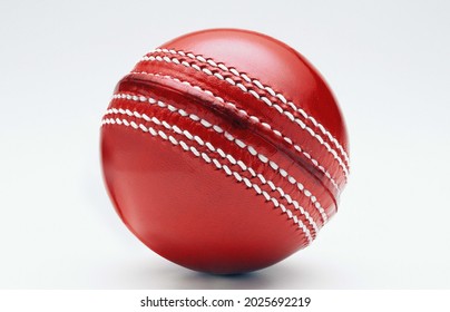 Red Cricket ball leather hard circle stitch close-up new isolated on white background.