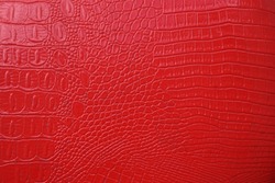 Red Crocodile Skin Artificial Leather With Waves And Folds On PVC Base. Mock Up Space. Empty Background Of Red Crocodile Leather. Mockup Texture Backdrop. Top View Image.