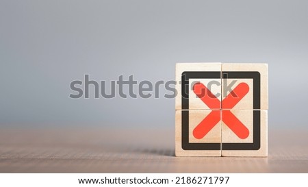 Red Cross mark, x, Wrong mark sign, Rejection sign in wooden cube stack. Concept of negative decision making or choice of vote with copy space for background or text.