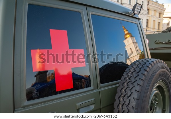 A\
red cross on the window of a military medical vehicle of the\
Ukrainian army. Exhibition of military equipment in Kiev. Modern\
military technology. Ukraine. Kiev. October 15,\
2021
