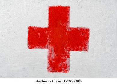 Red Cross Painted By Hand On White Wall. First Aid Kit Medical Icon. Medicine Health Hospital Sign Or Emergency Medicine Symbol, Health Care.