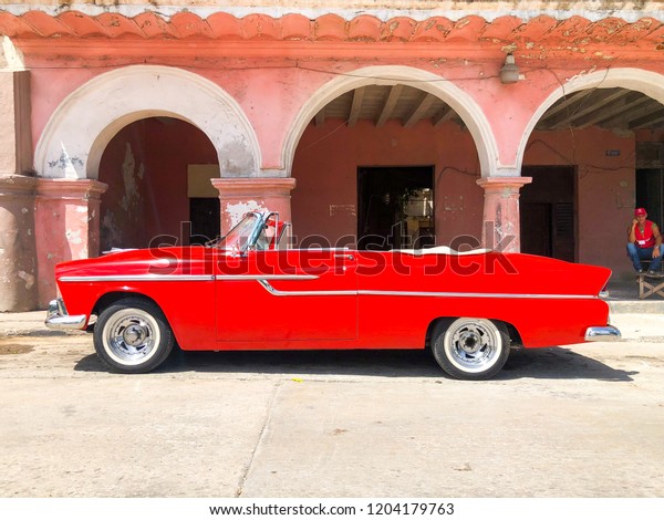 Red Cuban vintage car. American\
classic car drives on the main road in Havana Cuba.\
10/02/2018